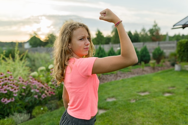 Teen muscle girl flexing biceps