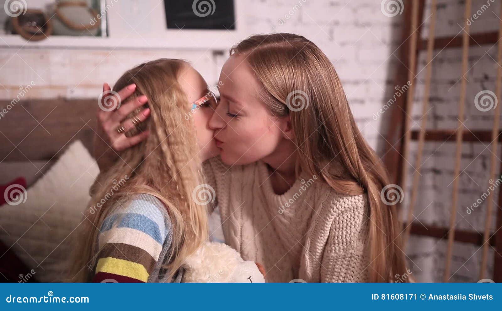 Young teen girls kissing moms